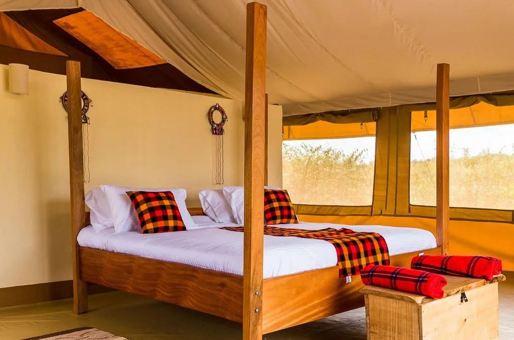 Inside a safari tent with twin beds and canvas walls